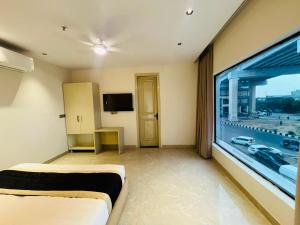 a living room with a large window and a tv at Hotel Grand Elite- Ghaziabad in Ghaziabad
