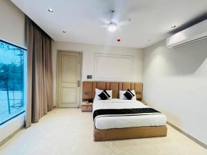 a bedroom with a bed and a large window at Hotel Grand Elite- Ghaziabad in Ghaziabad