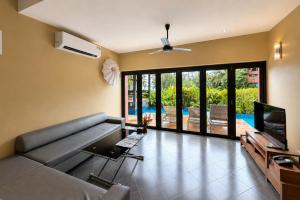 a living room with a couch and a television at Tha Lane Bay Villas in Tha Lane Bay
