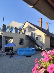 a house with a swimming pool in front of it at Norbi Vendégház in Balatonszárszó