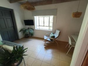 a living room with a table and chairs and a window at הקן לציפורים נודדות in Rosh Pinna
