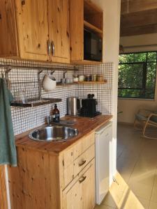 a kitchen with a sink and wooden cabinets at הקן לציפורים נודדות in Rosh Pinna