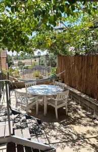 a table and chairs on a patio under a tree at הקן לציפורים נודדות in Rosh Pinna