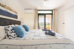 a bedroom with a large bed with blue pillows at Paz Ocean View, 2 Air Conditioners, Wifi, Heated pool in San Miguel de Abona