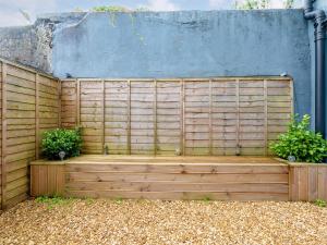 a wooden fence with two potted plants on it at Y Cwtsh in Llandeilo