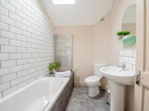a bathroom with a tub and a toilet and a sink at Y Cwtsh in Llandeilo