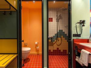 a bathroom with a shower and a toilet and a sink at ibis Styles Tbilisi Center in Tbilisi City