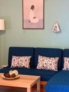 a blue couch with a table and a plate of food at AH-REMINI GARDEN Home in Siófok