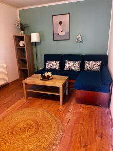 a living room with a blue couch and a coffee table at AH-REMINI GARDEN Home in Siófok