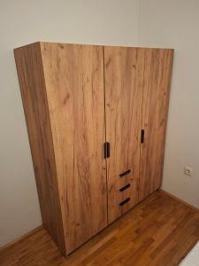 a large wooden cabinet in the corner of a room at Apartment Gonzales in Mostar