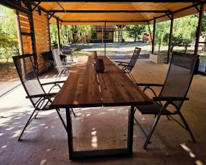 a long wooden table with chairs in a pavilion at Komondor Vendégház in Vácrátót