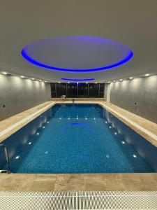 a large indoor swimming pool with a blue ceiling at Midyat Bay Grand Hotel in Midyat