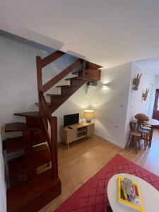 a living room with a staircase and a living room with a table at Casa dos Pintos in Paredes de Coura