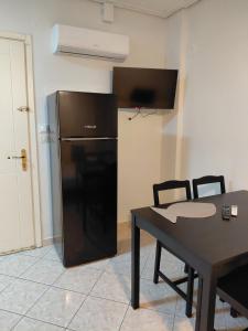 a kitchen with a black refrigerator and a table at Platamon house in Platamonas