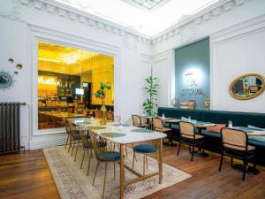 a dining room with tables and chairs and a restaurant at Mercure Nantes Centre Passage Pommeraye in Nantes