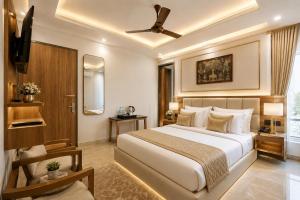 a hotel room with a bed and a ceiling fan at Hotel Grand Villa Suites Near Delhi International, IGI Airport in New Delhi