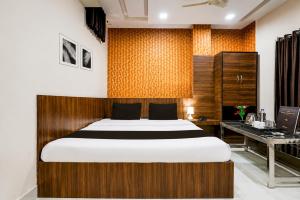 a bedroom with a large bed and a desk at Hotel Swarat by TruStay in Satna