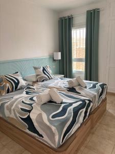 a large bed in a bedroom with green curtains at 42 Guacimeta Club in Los Pocillos +13 photos