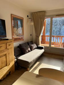 ein Wohnzimmer mit Sofa und Fernseher in der Unterkunft Résidence Albane, T3 entièrement refait in Vars