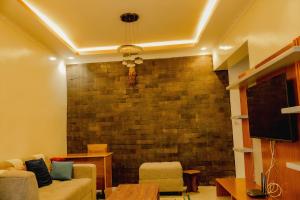 a living room with a brick wall and a couch at Sabyinyo Crest in Cyuve