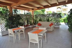 a patio with tables and chairs and a couch at Eu ropa Hotel in Nereto
