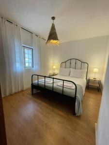 a bedroom with a bed and two lamps and a window at Casa dos Pintos in Paredes de Coura