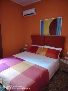 a bedroom with a large bed with colorful sheets at MARA E MONTI in Tossicia