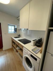 a kitchen with a washing machine and a sink at Casa dos Pintos in Paredes de Coura +2 photos
