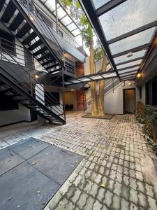 arium of a building with a staircase and a tree at Add Hotéis Mascote in São Paulo