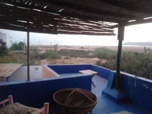 a porch with blue walls and a view of a field at Tamraght banana house in Agadir
