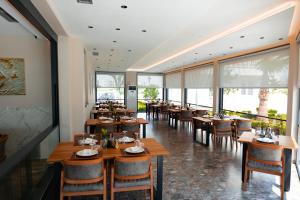 a restaurant with wooden tables and chairs and windows at Sirena Garden Resort in Tale