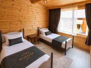 a bedroom with two beds in a log cabin at Beş Evler Apart in Uzungöl