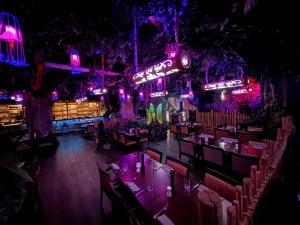 a restaurant with tables and neon signs at night at Bayside in Scharbeutz +97 photos
