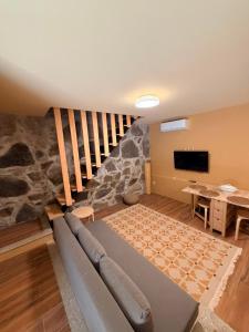 a living room with a couch and a rock wall at Quinta de Águas Mortas in Gestaco
