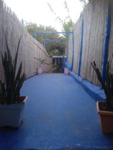 a patio with potted plants and a wooden fence at Tamraght banana house in Agadir