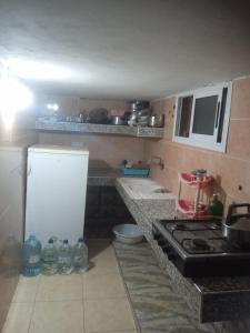 a small kitchen with a stove and a refrigerator at Tamraght banana house in Agadir
