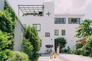 a building with two people standing outside of it at Tree House Café & Homestay in Tongluo