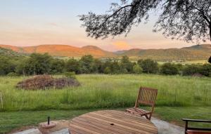 a wooden chair sitting on a table in a field at Shallow Pig Cottage in Parys