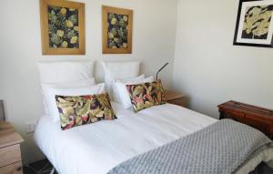 a bedroom with a white bed with two pillows at Shallow Pig Cottage in Parys