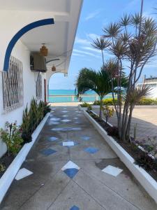 a walkway with palm trees and the ocean in the background at BlackPoint in Ballenita