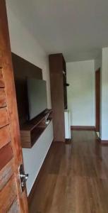 an empty room with a kitchen with wooden floors at Chácara Encanto do Horizonte in Ibiapina