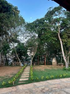 a path in a park with trees and a building at Chácara Encanto do Horizonte in Ibiapina