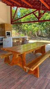 a large wooden table sitting on a wooden deck at Chácara Encanto do Horizonte in Ibiapina