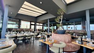 a restaurant with tables and chairs in a room at Bayside in Scharbeutz