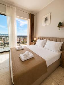a bedroom with a bed and a large window at Hotel Aleksandrus Jardin in Durrës