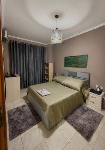 a bedroom with a large bed and a window at SiMar Apartment Tirana in Kashari