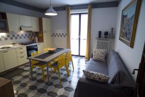 Il comprend une cuisine et un salon avec une table et un canapé. dans l'établissement Casa Clementi, à Barolo