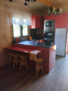 a kitchen with red walls and a counter with stools at Casa dos Cortinhais 2 in Oliveira de Frades