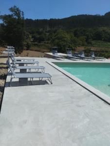 a row of chairs and a swimming pool at Casa dos Cortinhais 2 in Oliveira de Frades