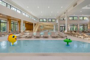 a swimming pool with a slide in a building at Essense Baltic Resort & SPA in Dziwnów